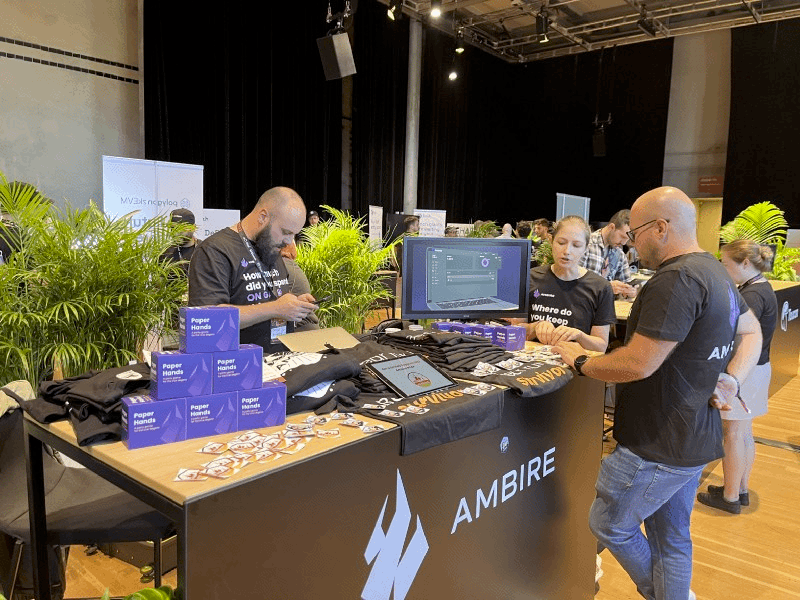 Ambire Wallet's team members standing around a table at an event