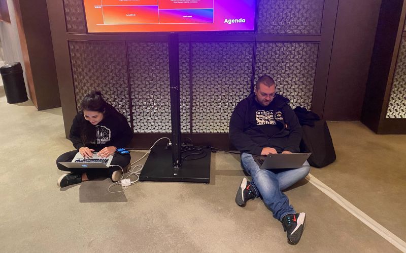 Vesi (biz dev) and Emil (product lead) working on their laptops while seated on the ground